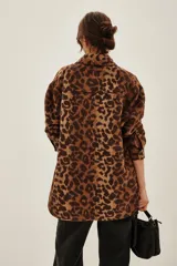 Tapado tipo sobrecamisa con estampado animal print, de corte recto y largo a la cadera. Presenta cuello camisero, cierre frontal con botones y dos bolsillos frontales con solapa.