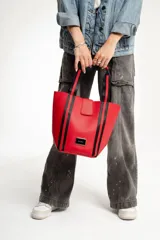 Bolso negro tipo tote con correa de hombro y necessaire con cierre.