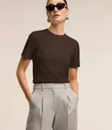 Blusa básica de tejido rib acanalado, con cuello redondo ajustado y mangas cortas. Presenta un diseño minimalista y entallado.