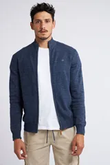 Campera tejida de punto en color verde militar, con cierre frontal completo, cuello elevado y ajuste regular. Presenta un diseño texturizado con logo bordado en el pecho y puños acanalados.