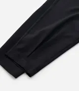 Pantalón zanahoria de vestir negro, con cintura alta, elástico en la espalda, bolsillos laterales, botón metalizado y pliegues delanteros.