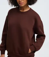 Buzo femenino de cuello redondo y manga larga, confeccionado en tejido de algodón con felpa. Presenta un diseño básico sin estampado, con puños y ruedo ajustados en tejido rib.