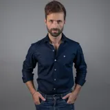 Camisa sport azul marino para hombre, confeccionada en 100% algodón, con fit regular, cuello clásico y mangas largas con puños abotonados. Presenta un pequeño logo bordado en el pecho.