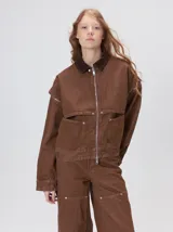 Campera de denim a rayas verticales con cuello de pana en color bordó. Presenta cierre frontal, mangas desmontables con cierre en los hombros, canesú en el pecho y bolsillos de parche cuadrados.