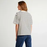 Remera oversize de algodón color blanco con rayas horizontales negras, cuello redondo y mangas cortas.
