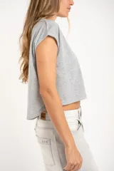 Remera gris de algodón con poliéster, corte crop, mangas cortas y bolsillo en el pecho.