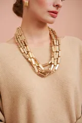 Collar dorado de múltiples hilos con cuentas rectangulares.