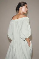 Vestido midi confeccionado en lino 100%, con escote recto elástico estilo hombros descubiertos, mangas abullonadas y detalle de pliegues en la cintura. Cuenta con bolsillos laterales ocultos y bajo asimétrico.