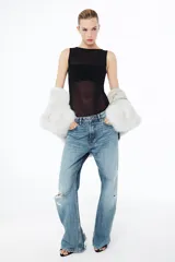 Body sin mangas de cuello redondo, confeccionado en una combinación de tul transparente y paneles de tela opaca a tono. Presenta un diseño ajustado con cierre inferior mediante botones a presión.