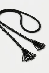Collar largo negro de cuentas de resina con detalles en latón, diseñado para usar con múltiples vueltas alrededor del cuello.