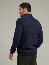 Cardigan azul de punto con cuello esmoquin, cierre con botones de madera y bolsillos frontales.