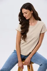 Remera de algodón color verde menta, con escote redondo y mangas corta con detalles de volados sutiles en los puños.