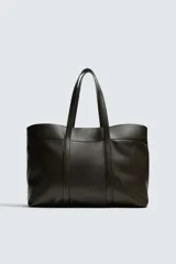 Bolso tipo shopper de piel en color negro, con diseño minimalista, doble asa de mano y compartimento principal con cierre magnético.