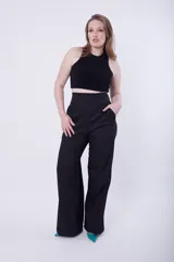 Pantalón de vestir negro de tiro alto y corte palazzo, con bolsillos laterales.