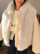 Campera puffer oversize color marrón, con paneles frontales y traseros de pelo sintético suave. Presenta mangas acolchadas, cierre frontal y bolsillo con cierre en la manga.