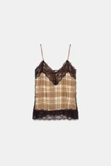 Top lencero de escote en pico con tirantes finos ajustables. Presenta un estampado de cuadros en tonos beige y marrón, con detalles de encaje negro en el escote y en el ruedo.