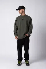 Buzo de cuello redondo en algodón rústico con efecto de lavado gastado, corte oversize y estampa frontal pequeña con texto.