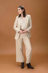 Pantalón sastrero de corte ancho y tiro alto, con diseño de líneas limpias, bolsillos laterales y cierre frontal con botón. Presenta una caída fluida y estructura amplia.