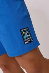 Short de baño tipo volley, color morado/rosado, con cordón ajustable en la cintura y un pequeño parche estampado en la pierna derecha.