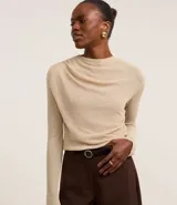 Blusa de punto leve color beige, con cuello degagê, mangas largas y fruncido lateral.