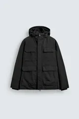 Parka técnica de corte relajado con interior ligeramente acolchado. Presenta cuello subido con capucha ajustable, cierre frontal con cremallera oculta por solapa con botones a presión, y cuatro bolsillos frontales de plastrón con solapa. Incluye cintura ajustable con cordón interior, puños con rib y aberturas laterales con cremallera en el bajo.