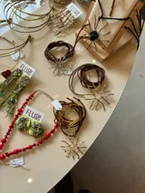 Collar con dije de alpaca y bronce hecho a mano con diseño de estrella solar, suspendido de un tiento de gamuza ajustable.