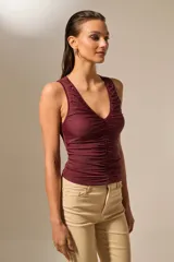 Top negro sin mangas de poliéster, con escote en V profundo y frunces en la parte delantera.