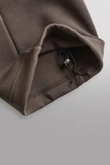 Pantalón jogger relaxed fit Zara Athleticz de tejido técnico compacto elástico con mezcla de algodón. Presenta cintura elástica ajustable con cordón, bolsillos laterales en la cadera, bolsillo trasero con cierre de cremallera, bajo ajustable con elástico y detalle de logo estampado en la pernera.