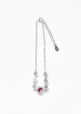 Pulsera de plata 925 con cadena de eslabones finos, decorada con pequeñas zirconias circulares y un dije central en forma de corazón con una zirconia fucsia rodeada de piedras brillantes.