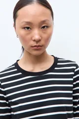 Remera de manga larga con diseño de rayas horizontales en blanco y negro, cuello redondo y corte clásico.