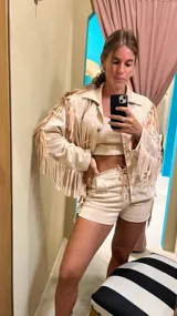 Campera color beige de gamuza sintética con flecos en mangas, espalda y ruedo.