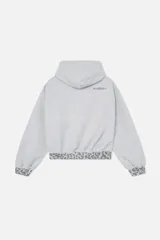 Hoodie cropped de Scuffers en color gris melange, con diseño oversized y detalles distressed. Presenta terminaciones con estampado animal print en la capucha, los puños y la cintura, e incluye un bolsillo frontal tipo canguro.