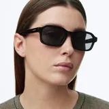 Lentes de sol con montura cuadrada de acetato negro y lentes polarizadas oscuras.