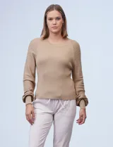 Buzo color beige de tejido combinado con mangas largas caladas y cuello redondo.