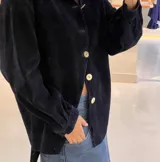 Camisa de pana azul marino con cuello clásico, cierre frontal de botones grandes en contraste y mangas largas con puños abotonados.
