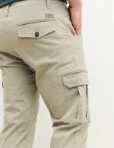 Pantalón de gabardina color marrón, corte slim fit, con bolsillos laterales tipo cargo.