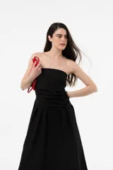Vestido largo blanco con escote strapless y cuerpo fruncido. Posee falda amplia y fluida con bolsillos.
