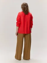 Camisa de lino liviano color tostado, con silueta relajada, cuello mao, alforzas verticales frontales, mangas con volumen y puños elastizados con volados.