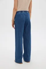 Pantalón de jean azul de corte recto, tiro medio, con cintura elástica con cordón de ajuste y bolsillos laterales.