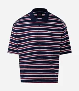 Remera polo de algodón con diseño a rayas horizontales en azul marino, rojo y blanco, corte boxy amplio, mangas cortas y cuello polo con botones. Presenta un pequeño bordado en el pecho.