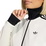 Campera deportiva Adidas con cierre frontal, cuello alto, bolsillos laterales con cierre y puños y cintura acanalados. Presenta el diseño icónico de tres rayas en las mangas y el logo del trébol bordado en el pecho.