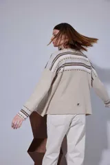 Blazer de pana color crema con solapas clásicas, cierre frontal de un botón y puños con detalle de tejido a rayas. Presenta un corte estructurado y elegante.