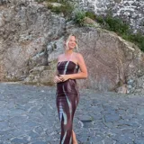 Vestido largo marrón con estampado abstracto en tonos celeste y blanco. Diseño strapless ajustado al cuerpo con abertura lateral en la falda.