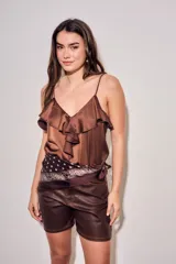 Musculosa de satén color marrón, con escote en V, tirantes finos y detalle de volados frontales.