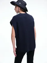 Chaleco de tejido de punto con lana y alpaca, de corte relajado y caída recta. Presenta laterales abiertos con cierre de botones y cuello redondo.