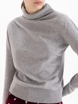 Sweater de lana merino color negro, con cuello medio alto y detalle de frunces en los hombros que aportan volumen. De calce regular y tejido suave.