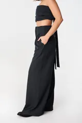 Pantalón de tiro alto con corte holgado y pierna ancha. Presenta bolsillos laterales ocultos en la costura y una faja desmontable ajustable en la cintura.