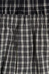 Pack de dos calzoncillos tipo boxer de tela suave, con cintura elástica y bragueta de botones. Ambos presentan diseños a cuadros en tonos blanco y negro.