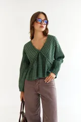 Blusa de algodón con estampado de cuadros en tonos verdes, con escote en V, mangas largas con puños elásticos y detalle de frunces en el frente y la espalda.