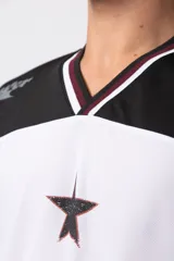 Camiseta blanca de poliéster con cuello en V negro y ribete rojo. Estampado frontal con una estrella negra y texto con efecto desgastado. Mangas cortas con números '0' y '1' en color rojo.